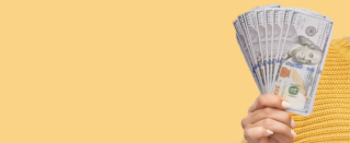 Hand holding money on yellow background