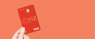 Hand holding a Visa Signature Rewards Credit Card.