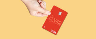 Hand holding a Visa Signature Rewards Credit Card.